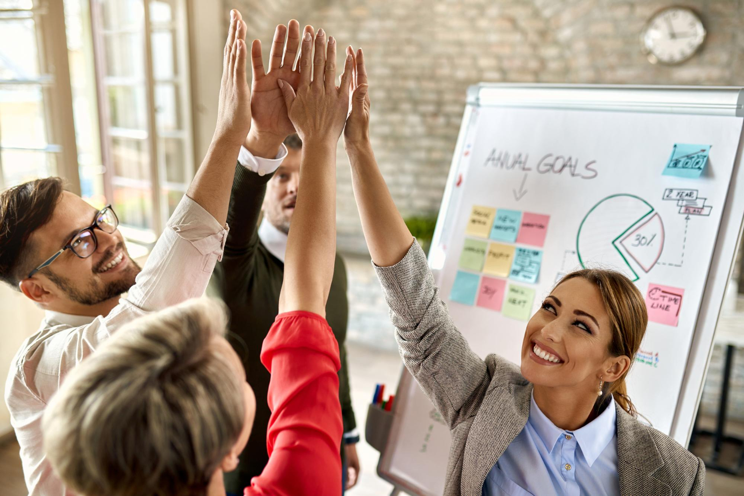 happy-business-team-with-raised-hands-celebrating-their-success-office